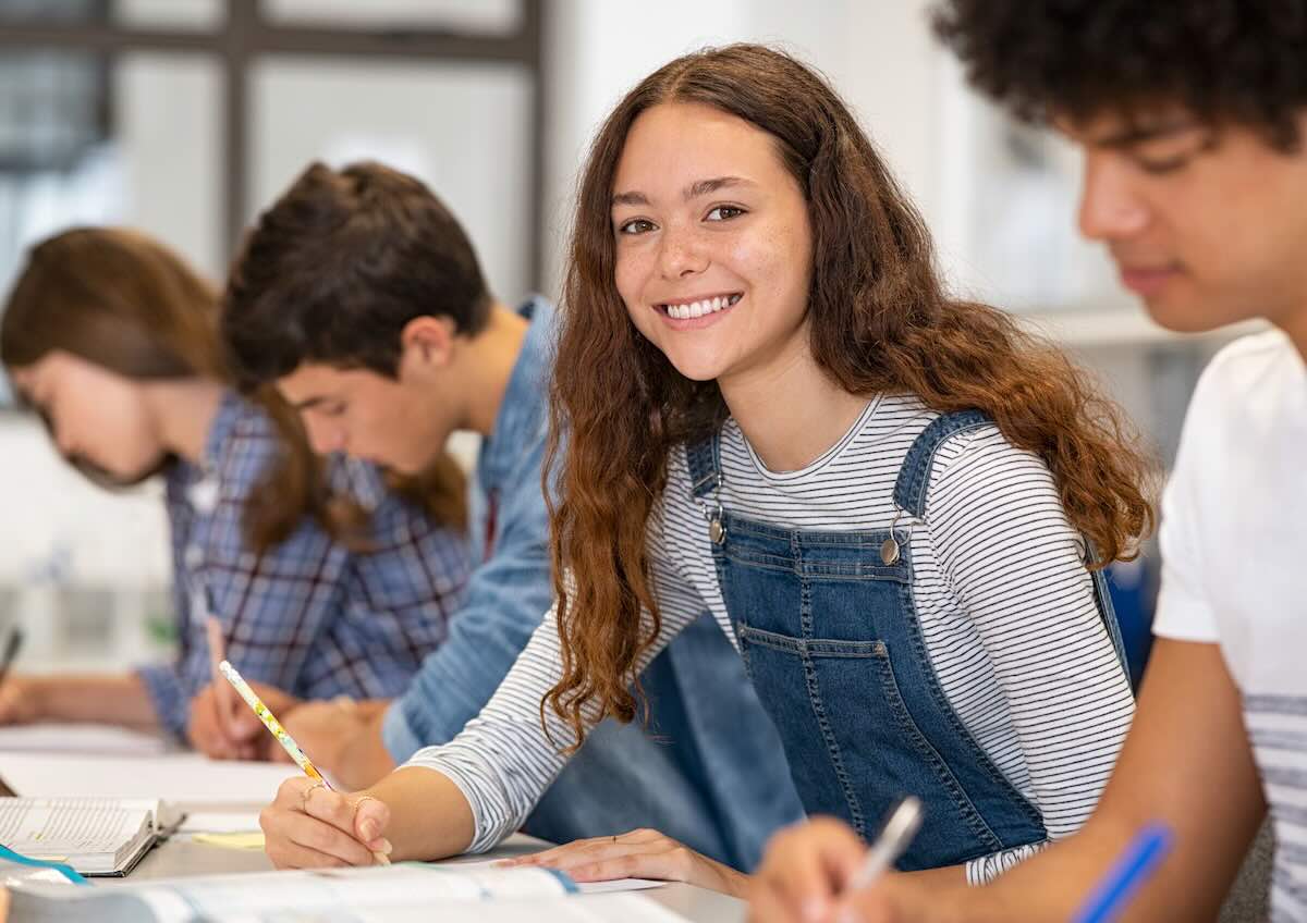 Alumnos concentrados tomando apuntes en una clase durante su año escolar en el extranjero.